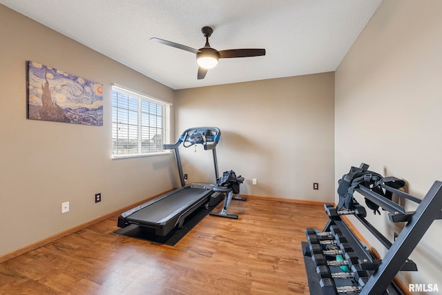 exercise area with a textured ceiling, ceiling fan, and light hardwood / wood-style flooring