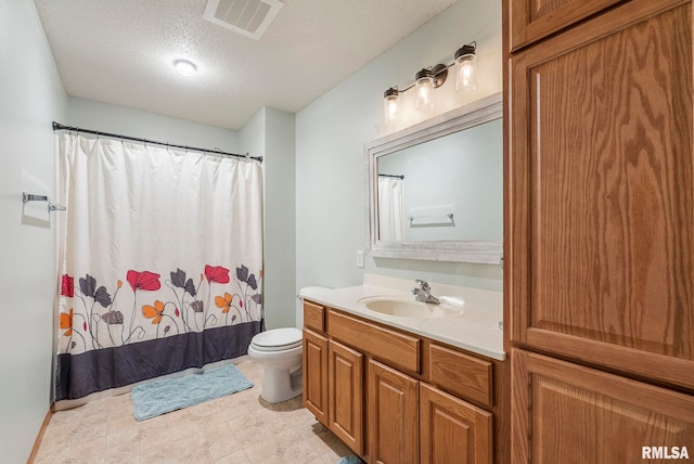 bathroom with vanity, a textured ceiling, and toilet