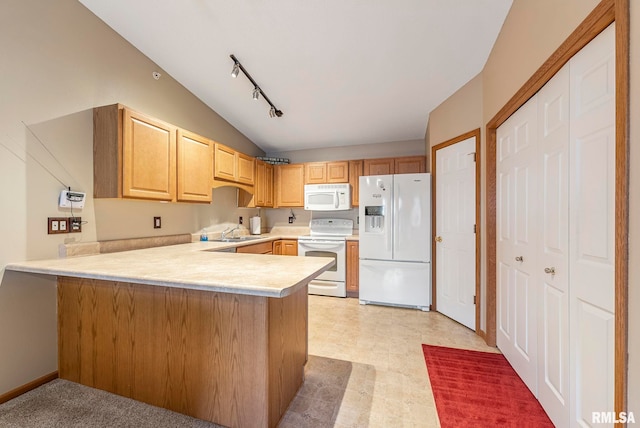 kitchen featuring sink, white appliances, vaulted ceiling, and kitchen peninsula