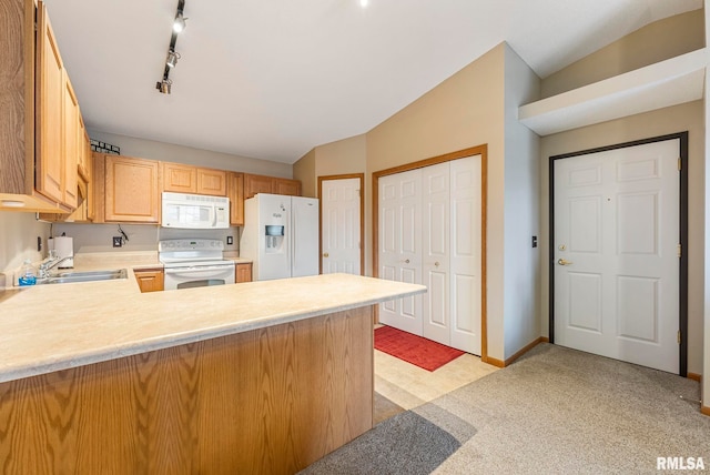 kitchen with sink, track lighting, kitchen peninsula, light carpet, and white appliances