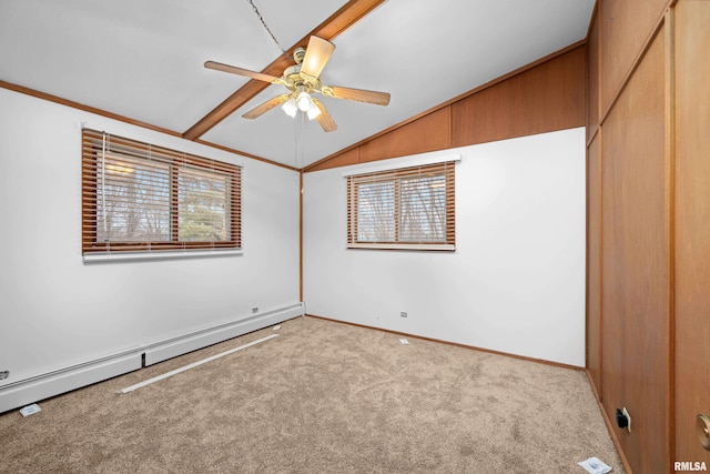 carpeted empty room featuring vaulted ceiling, crown molding, ceiling fan, and baseboard heating