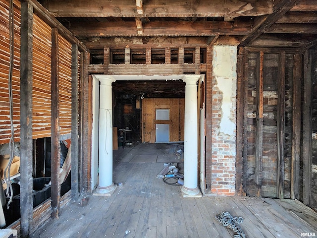 misc room with hardwood / wood-style flooring and decorative columns