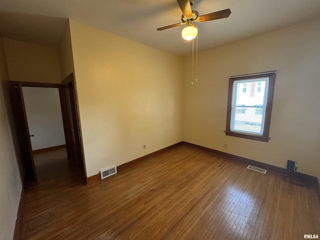 empty room featuring ceiling fan and dark hardwood / wood-style flooring