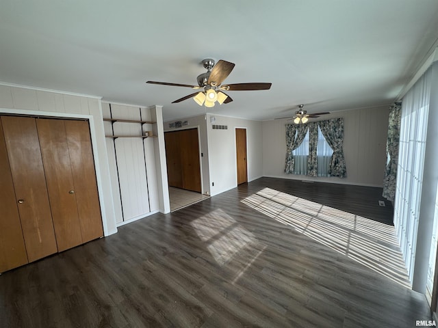 unfurnished bedroom featuring dark wood-type flooring, ornamental molding, and ceiling fan