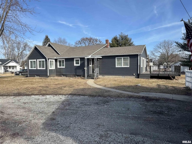 ranch-style house with a wooden deck and a front lawn