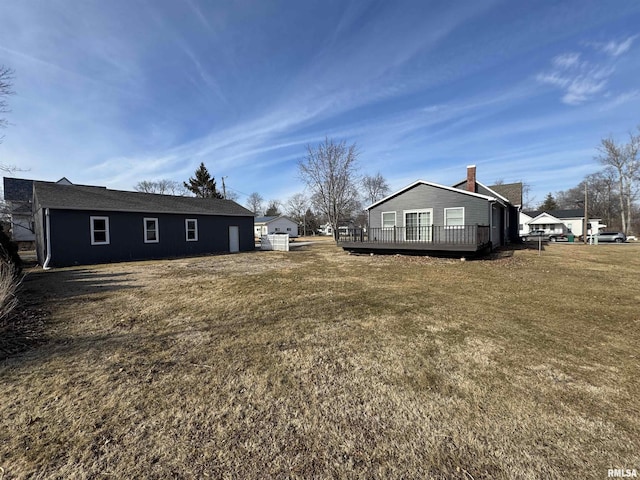 exterior space with a wooden deck and a lawn