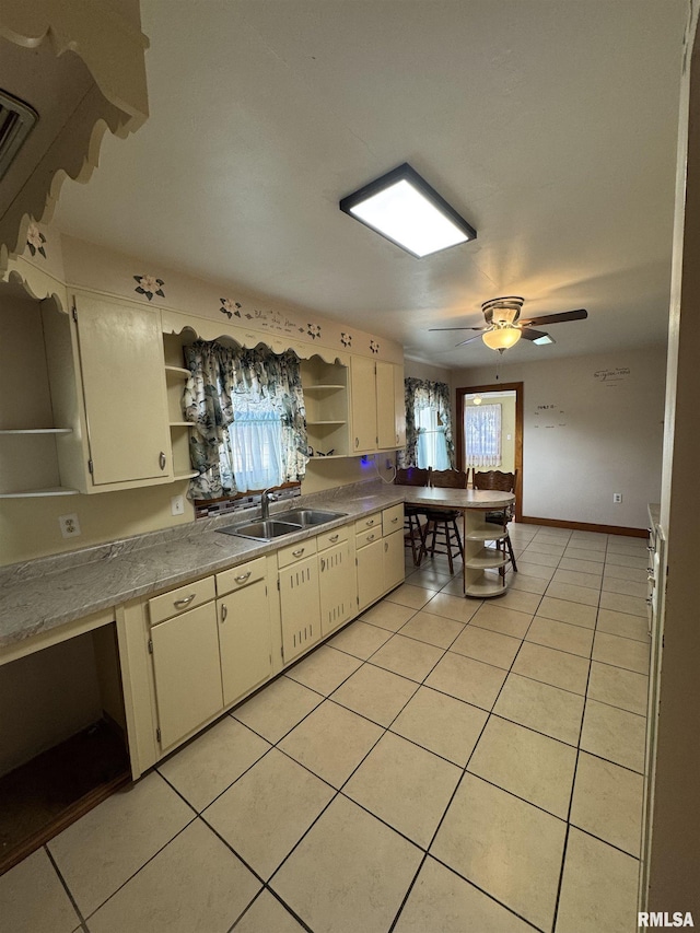 kitchen featuring sink, light tile patterned floors, and ceiling fan