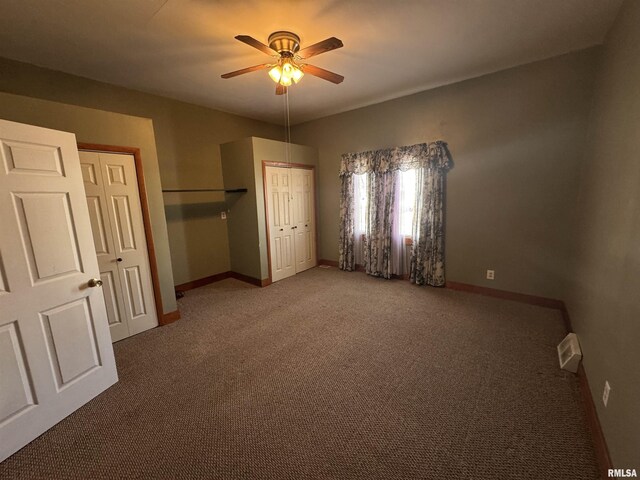 unfurnished bedroom featuring ceiling fan and dark colored carpet