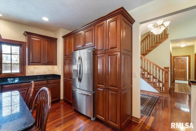 kitchen featuring a notable chandelier, dark hardwood / wood-style flooring, stainless steel fridge with ice dispenser, and backsplash