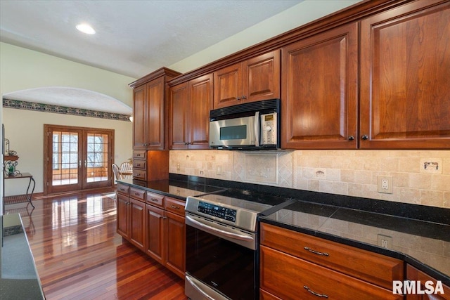 kitchen with backsplash, dark wood-type flooring, french doors, and appliances with stainless steel finishes