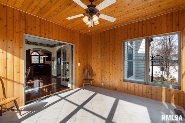 unfurnished sunroom with wood ceiling and ceiling fan