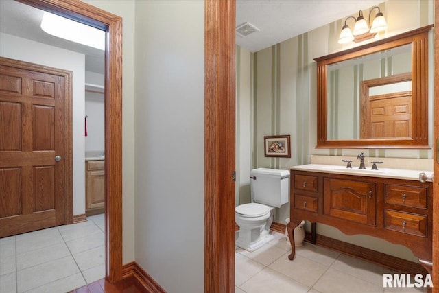 bathroom with tile patterned flooring, vanity, and toilet