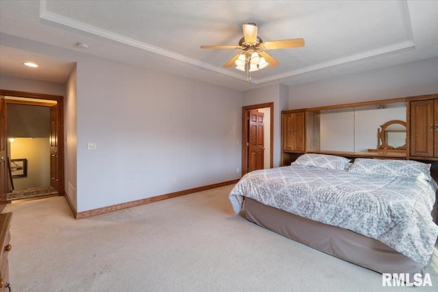 carpeted bedroom featuring ceiling fan and a tray ceiling