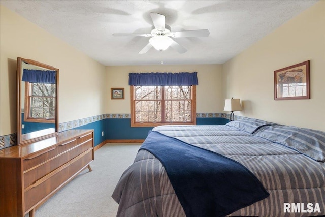 bedroom featuring multiple windows, light colored carpet, and a textured ceiling