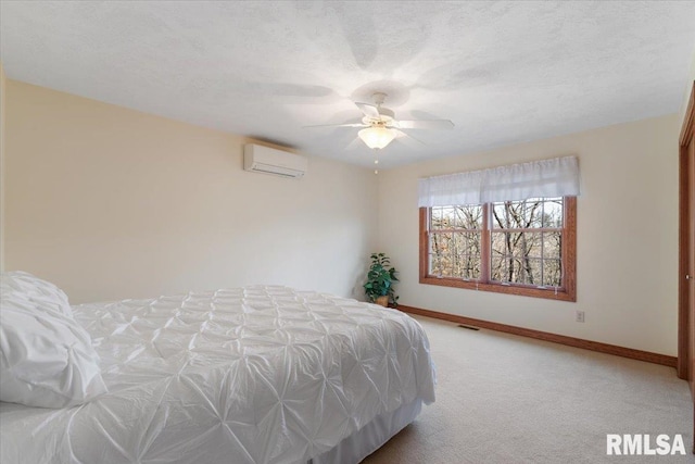 carpeted bedroom with ceiling fan, a wall unit AC, and a textured ceiling