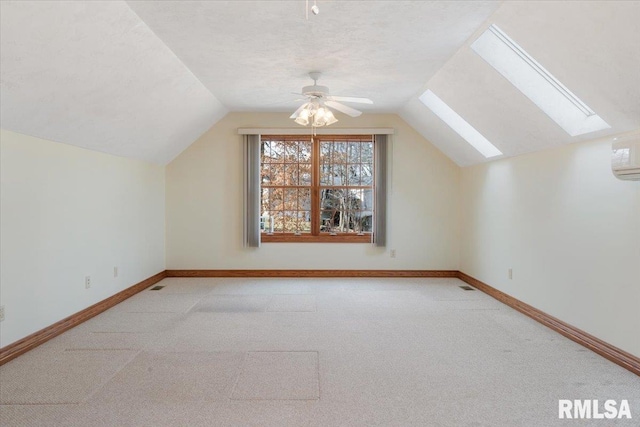 additional living space featuring ceiling fan, vaulted ceiling with skylight, light colored carpet, and a textured ceiling