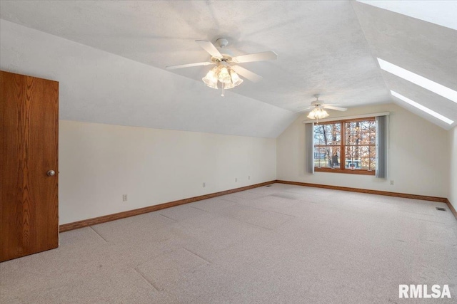 bonus room featuring ceiling fan, lofted ceiling with skylight, carpet floors, and a textured ceiling