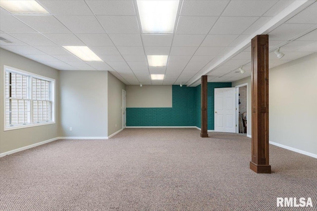 basement with a paneled ceiling, rail lighting, and carpet floors