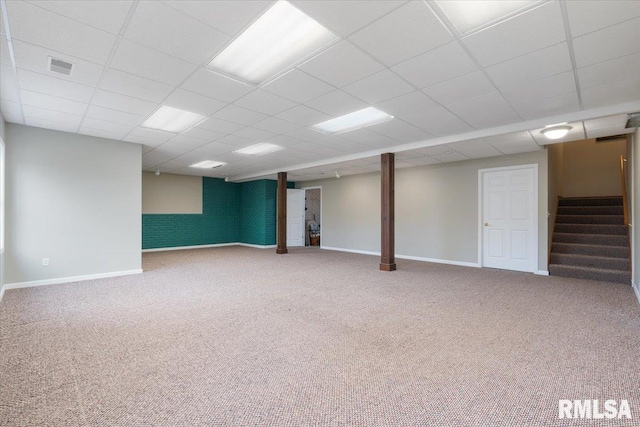 basement with a paneled ceiling and carpet floors