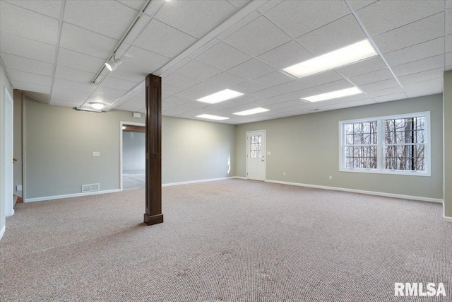 basement featuring light colored carpet and a drop ceiling