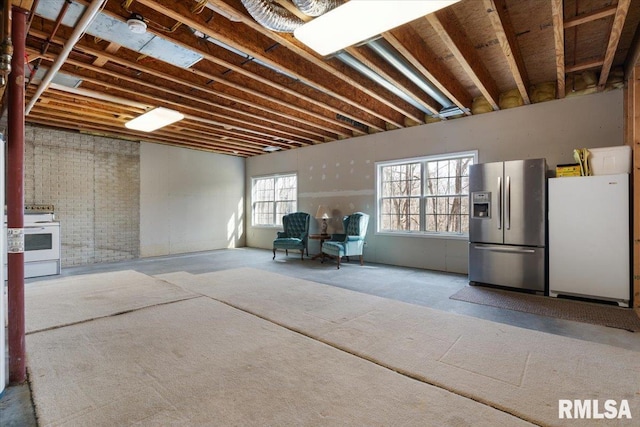 basement with white fridge and stainless steel fridge with ice dispenser