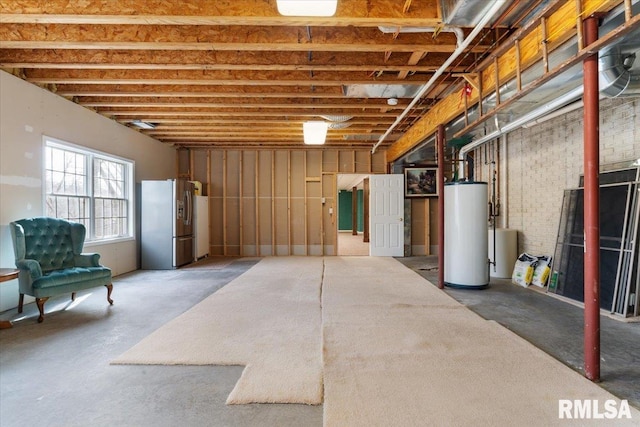 basement with stainless steel fridge with ice dispenser and gas water heater