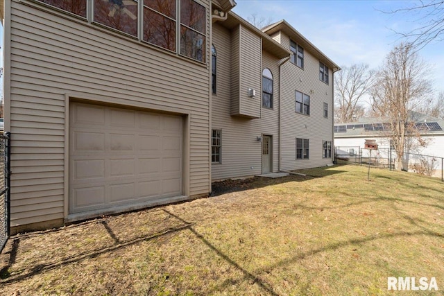 back of property featuring a yard and a garage