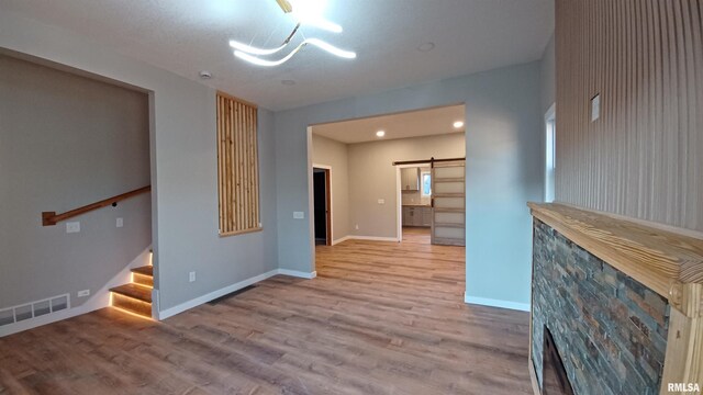 822 6th Ave S, Clinton, IA 52732 - unfurnished living room with wood-type flooring and a barn door