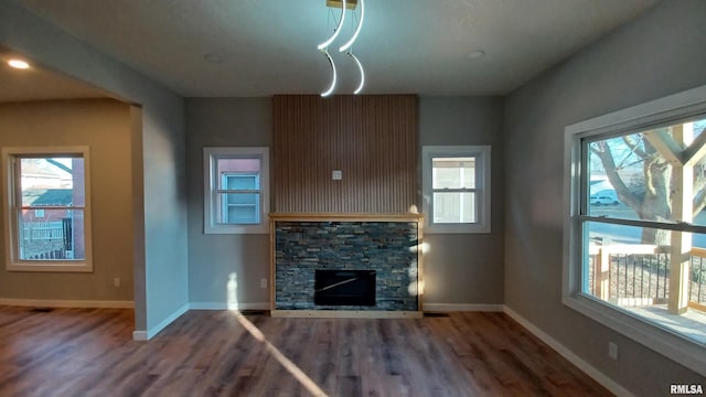 822 6th Ave S, Clinton, IA 52732 - unfurnished living room featuring a wealth of natural light, a fireplace, and dark hardwood / wood-style flooring