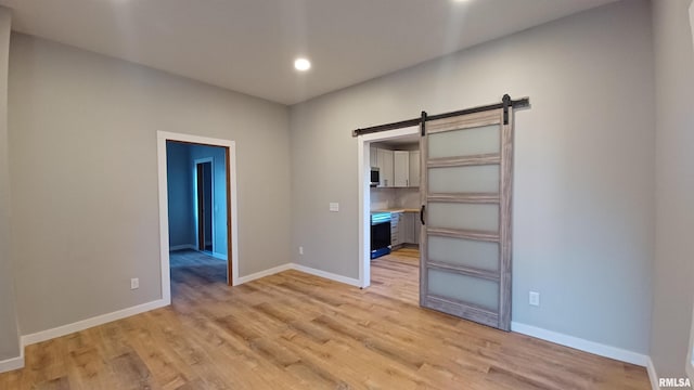 822 6th Ave S, Clinton, IA 52732 - interior space with a barn door and light hardwood / wood-style flooring