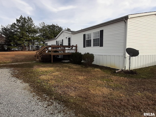 view of home's exterior featuring a wooden deck and a yard