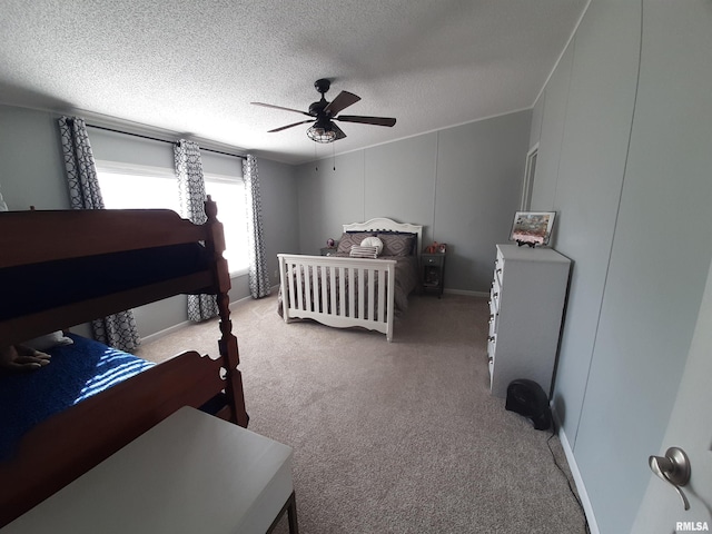 carpeted bedroom featuring ceiling fan and a textured ceiling