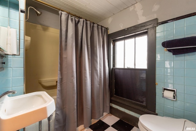 bathroom with tile walls, sink, a shower with curtain, and toilet