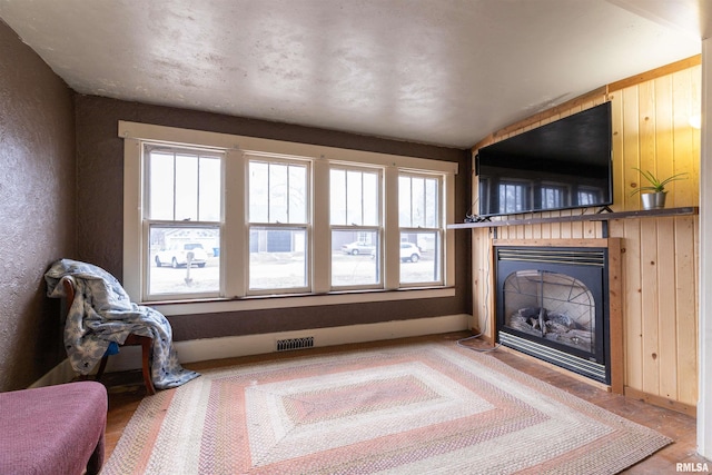 living room featuring hardwood / wood-style floors and wood walls