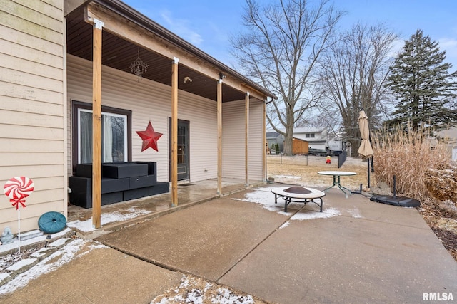 snow covered patio with an outdoor fire pit