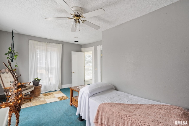 bedroom featuring light carpet, ceiling fan, and a textured ceiling