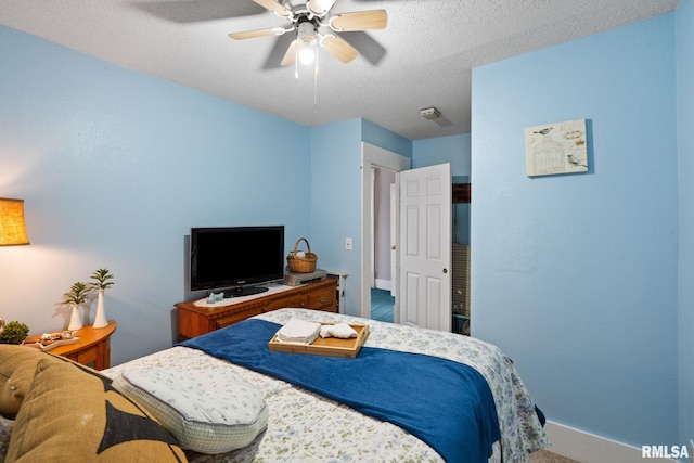 bedroom featuring ceiling fan, carpet flooring, and a textured ceiling