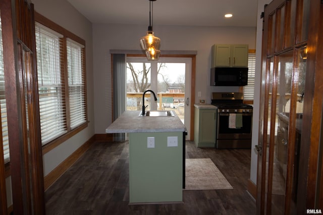 kitchen with pendant lighting, stainless steel gas stove, sink, a healthy amount of sunlight, and a center island with sink