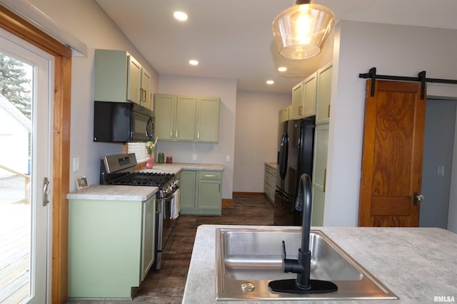 kitchen featuring pendant lighting, sink, green cabinets, black appliances, and a barn door