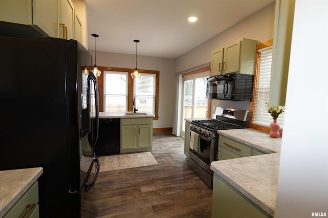 kitchen featuring pendant lighting, sink, dark wood-type flooring, black appliances, and green cabinetry