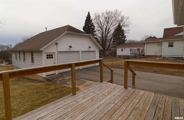 wooden deck featuring a garage and an outdoor structure