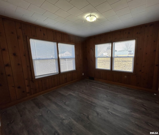 empty room featuring dark hardwood / wood-style floors and wooden walls