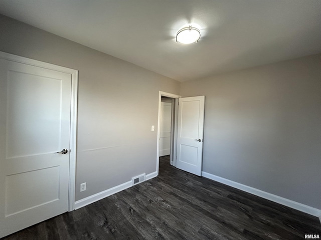 unfurnished bedroom featuring dark hardwood / wood-style flooring