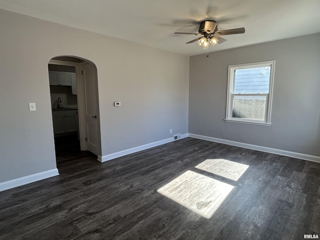 empty room featuring ceiling fan, dark hardwood / wood-style floors, and sink