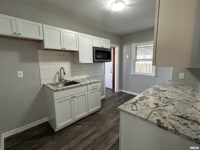 kitchen with white cabinetry, sink, and decorative backsplash