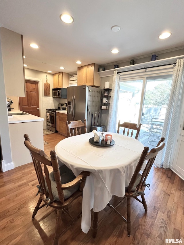 dining room with sink and light wood-type flooring