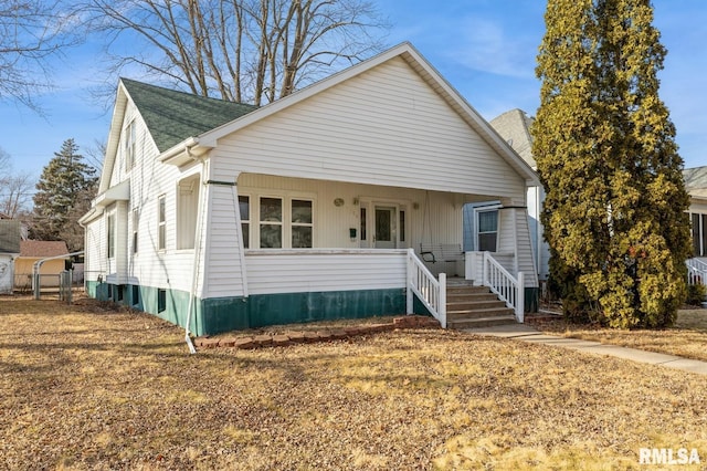 bungalow with covered porch and a front lawn