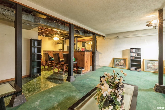 basement featuring indoor bar and a textured ceiling