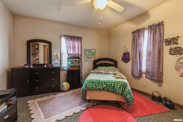 carpeted bedroom featuring multiple windows and ceiling fan