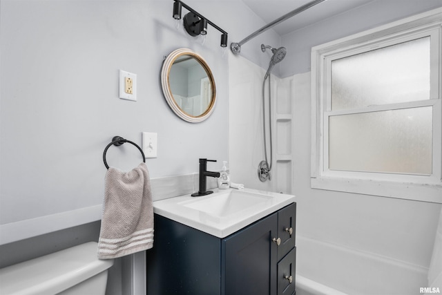 full bathroom featuring washtub / shower combination, vanity, and toilet